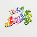 A colorful 'HAPPY Birthday' script cutout decoration with a rainbow gradient, displayed on a textured white background.