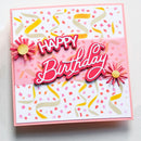 A square handmade birthday card with layered pink and white elements, colorful confetti and ribbon patterns, and raised 'HAPPY Birthday' text, photographed on a light neutral background.