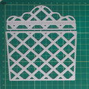 A silver metal cutting die with a basketweave lattice pattern, displayed on a green cutting mat with measurement markings.