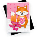 A handmade-style Valentine's Day greeting card featuring a cute orange fox holding a pink heart, with the words 'Happy Valentine's Day' in pink script. The card is layered with a pink heart-patterned background and white scalloped trim, shown standing on top of black and white envelopes against a white background.
