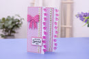 A handmade greeting card with pink and white polka dot patterns, a pink bow, and the text 'ON YOUR Special DAY' on a lavender surface with a blurred indoor background.