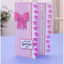 A handmade greeting card with a pink and white polka dot design, featuring a pink bow, gold dashed borders, and repeated bow motifs. The front card reads 'ON YOUR Special DAY' and is displayed standing upright on a light blue surface with a softly blurred indoor background.