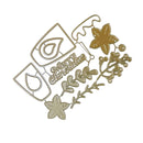 A gold-colored metal die-cut craft embellishment featuring Christmas motifs, including a 'Merry Christmas' script, a teardrop symbol, a star, and leafy sprigs, shown on a plain white background.