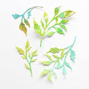 Four die-cut leaf and branch shapes in soft green, yellow, and aqua tones arranged on a white textured background.