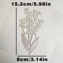 A floral die-cut stamp or embossing template showing a lily-of-the-valley design on textured off-white paper, with dimension labels reading 15.2cm/5.