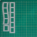 A set of clear plastic or acrylic template frames with grid lines and circular perforations, laid out on a green cutting mat with measurement markings.