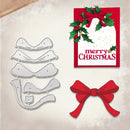 A holiday crafting set featuring a silver metal die cut file shaped like a Christmas ornament, a red bow, and a sample Christmas card decorated with green holly leaves and gold glitter accents.