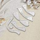 A set of white plastic or acrylic nail art stamping dies with silver metal cutting edges, arranged on a textured cream fabric background with cotton stems and a small wooden tool as props.