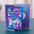 A handmade greeting card with a laser-cut design reading 'HUSBAND SENDING Love' surrounded by heart patterns, displayed in front of its blue backing card on a teal tabletop.