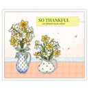 A square greeting card or art print featuring illustrated daffodils in two patterned pitchers, with a pale peach patterned band across the middle and a yellow tag reading “SO THANKFUL we found each other.”.