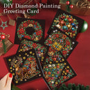 Six DIY diamond painting greeting cards with festive Christmas designs are displayed on a red background with holiday decorations. A hand with red nail polish is holding one card in the bottom left corner.
