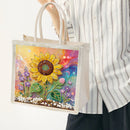 A person wearing a white and gray vertically striped button-up shirt holds a clear plastic tote bag. The bag features a colorful, beaded sunflower and wildflower design on the front panel, set against a clean white background.