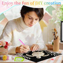A woman in a white sweater is shown in a decorated craft room, using a pink diamond painting pen to create a sea turtle design on a black canvas. The scene includes craft supplies like paintbrushes, small decorative items, and a banner at the top that reads 'Enjoy the fun of DIY creation'.