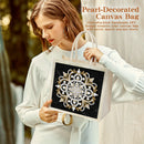 A woman in a white long-sleeve top holds a canvas tote bag with a black front panel featuring an ornate white and gold mandala design. The image includes promotional text in the upper right reading 'Pearl-Decorated Canvas Bag' with additional descriptive copy.