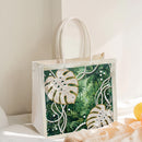 Decorative tote bag with tropical leaf design and rhinestones on a light background