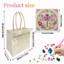 A clear plastic tote bag with beige handles on a white background, shown with product size measurements. A square diamond painting design featuring a colorful dragonfly is also shown, along with small gem and pearl accessories and a hand holding a pink tool.
