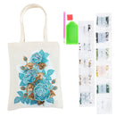 DIY diamond painting canvas tote bag with a blue and gold rose design, shown alongside its components: a green paint palette, pink and red paint sticks, and multiple sheets of small paint packets on a white background.