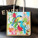 Tote bag with bird and floral design on a dark surface