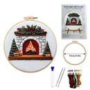 Embroidery DIY Art Kit shown with a completed circular embroidery hoop featuring a festive fireplace design, a smaller empty hoop with a 15cm/5.9in diameter marker, embroidery floss skeins, two needles, and an instruction booklet on a white background.