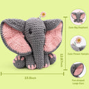 Crocheted elephant toy with pink ears on a green background, showing measurements and details.
