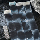 Decorative paper strips with star and heart patterns on a dark surface.