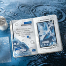 Open book with blue floral design and text on a water surface
