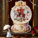 Decorative snow globe with a fantasy design featuring a woman, cards, and flowers on a dark background.