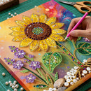 Handmade sunflower art project with beads and tools on a colorful background