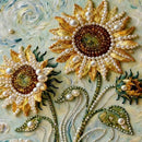 Decorative sunflower design with pearls and gold accents on a textured background