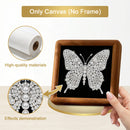 A hand holds a square wooden frame with a black canvas showing a sparkling butterfly design. The image includes callout circles highlighting the white canvas roll and a close-up of the rhinestone-and-pearl butterfly effect, with text reading 'Only Canvas (No Frame)', 'High-quality materials', and 'Effects demonstration'.