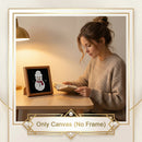 A woman sits at a wooden desk reading a book beside a small framed canvas display featuring a snowman design. The image includes a decorative border and the text 'Only Canvas (No Frame)', indicating the product is the canvas print rather than the frame.