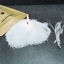 White wax melts or wax beads spilled on a dark gray surface next to a gold foil pouch labeled 'Melting Wax Set' and several white wicks.