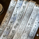 Decorative ribbon with floral and bird patterns on a wooden surface