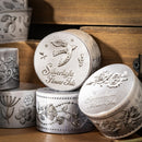 Decorative metal containers with engraved designs on a wooden surface