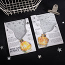 Two greeting cards with perfume bottle designs on a black surface with star decorations.