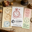 Three vintage-style clock-themed cards on a wooden surface with dried flowers.