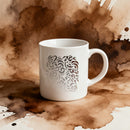 White mug with decorative pattern on a background of coffee stains