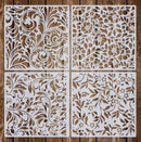 Four white laser-cut wooden panels with intricate floral and scroll patterns, arranged in a 2x2 grid on a rustic brown wood background.