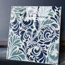 Decorative wall art with blue and white floral pattern on a dark background