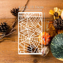 A white rectangular laser-cut metal sheet with a spiderweb pattern, shown on a rustic wooden background with autumn leaves and pumpkins. White text overlays indicate dimensions of 4 inch (10.