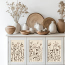 Decorative setting with ceramic vases, plates, and bowls on a cabinet with floral designs.