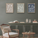 Living room with a wooden armchair, small table, and wall art featuring floral designs.