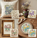 A collage showing butterfly and floral stencil or decal designs applied to home decor items: a cream pillow, a framed print, a ceramic vase, and a decorative plate, all arranged on a warm neutral tabletop with a vase of lavender in the background.