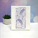 A square white art print or card featuring a purple botanical design with text, displayed upright on a white surface against a soft lavender and blue bokeh background. A small potted succulent sits to the left.