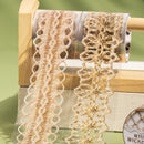 Two types of lace on a wooden reel with a green background