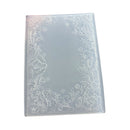 A clear plastic rectangular mold or stamp with embossed floral border designs along the edges, shown on a plain white background.