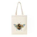 An off-white canvas tote bag with long handles, featuring a detailed embroidered bee design with blue wings and yellow flowers on the front, set against a plain white background.