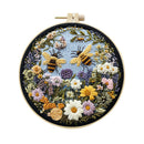 A circular embroidered floral and bee design mounted on a wooden hoop with a metal tension screw, shown against a plain white background.