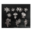 A set of clear plastic floral embellishments or stickers featuring various lily and flower designs, arranged on a black background.