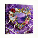 Decorative heart-shaped frame with colorful beads, flowers, and butterflies on a purple background